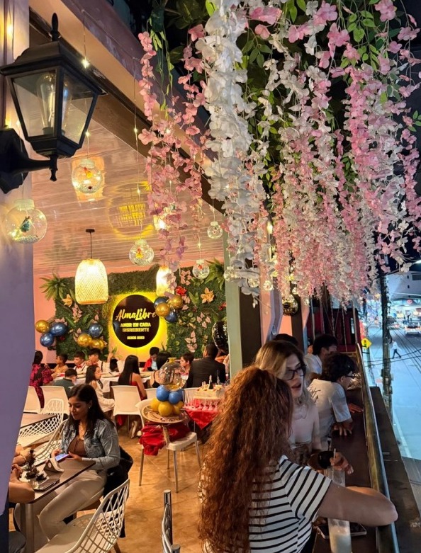 Interior de Almalibre con decoración floral y clientes